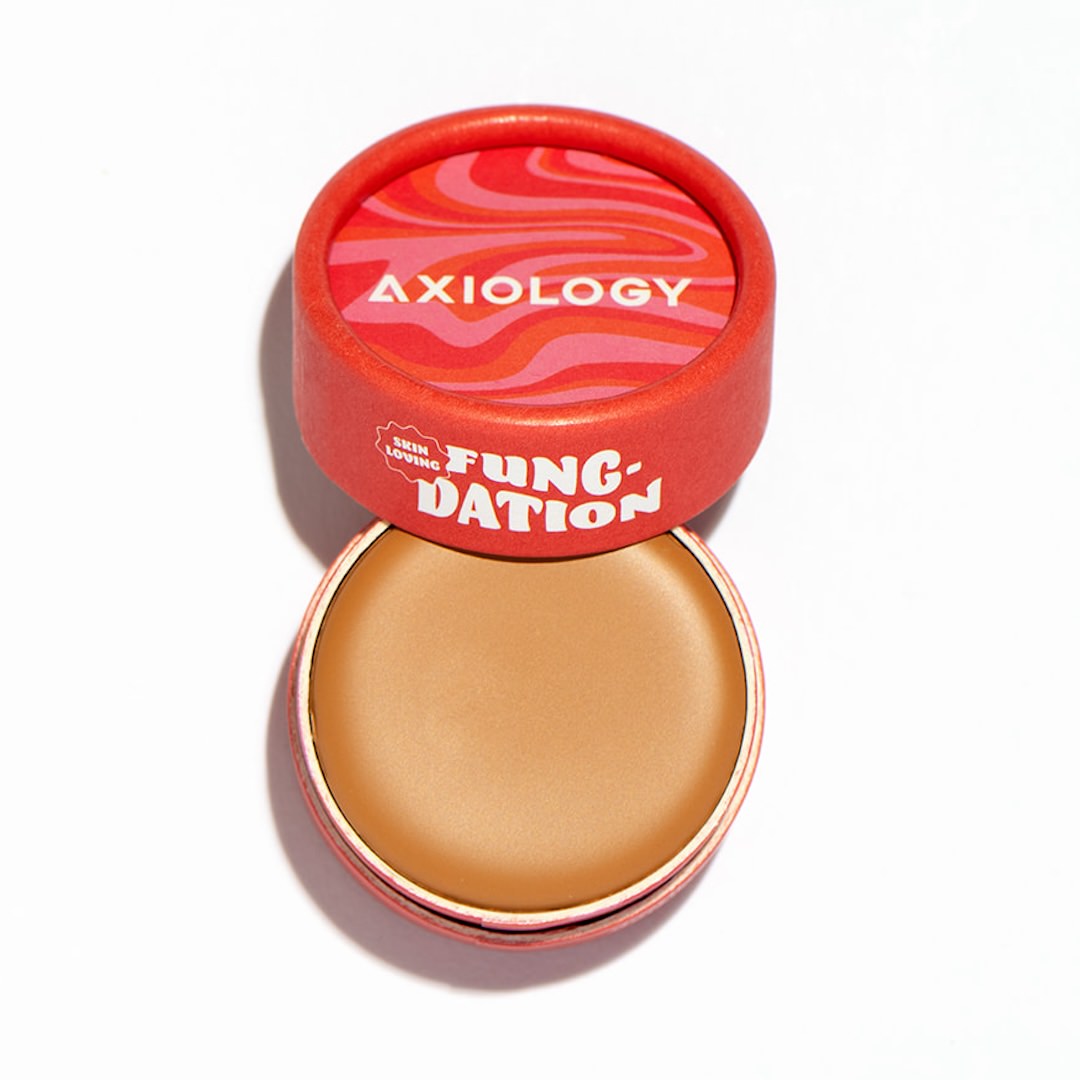 Cosmetic pot with red lid displaying 'Axiology' branding on a white background