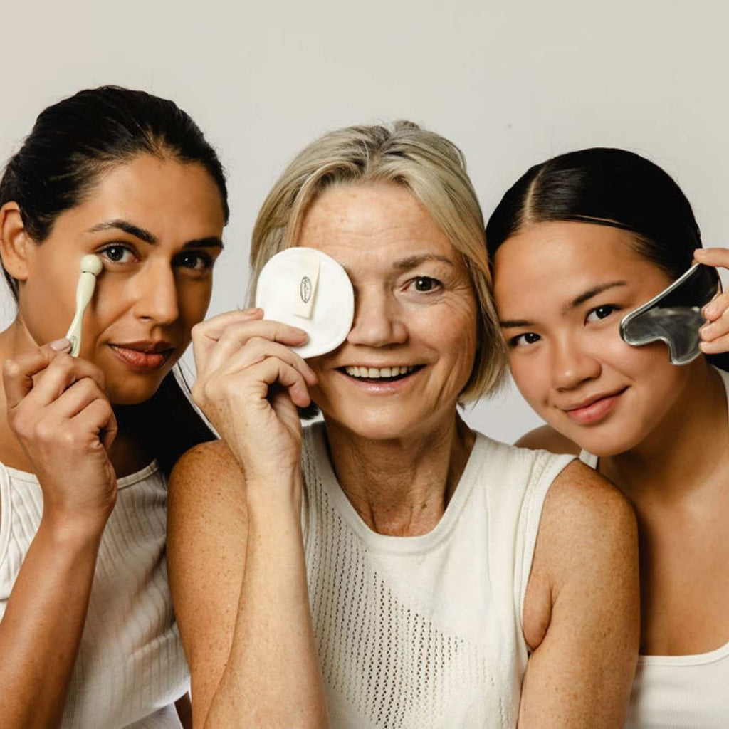 Three women using skincare tools against a plain background