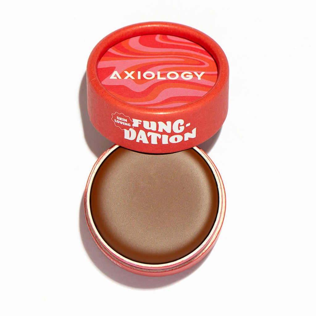 Axiology foundation pot with red lid on a white background