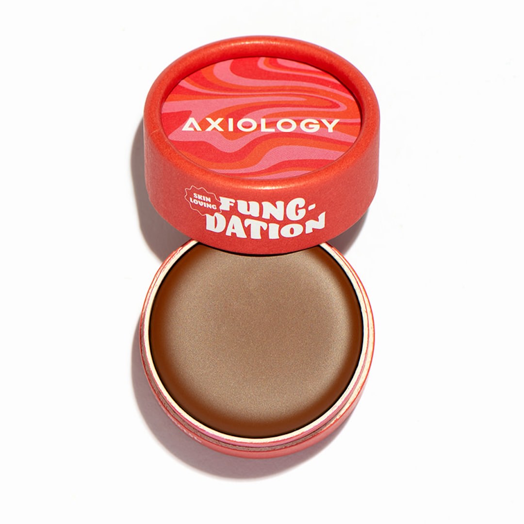 Axiology foundation pot with red lid on a white background