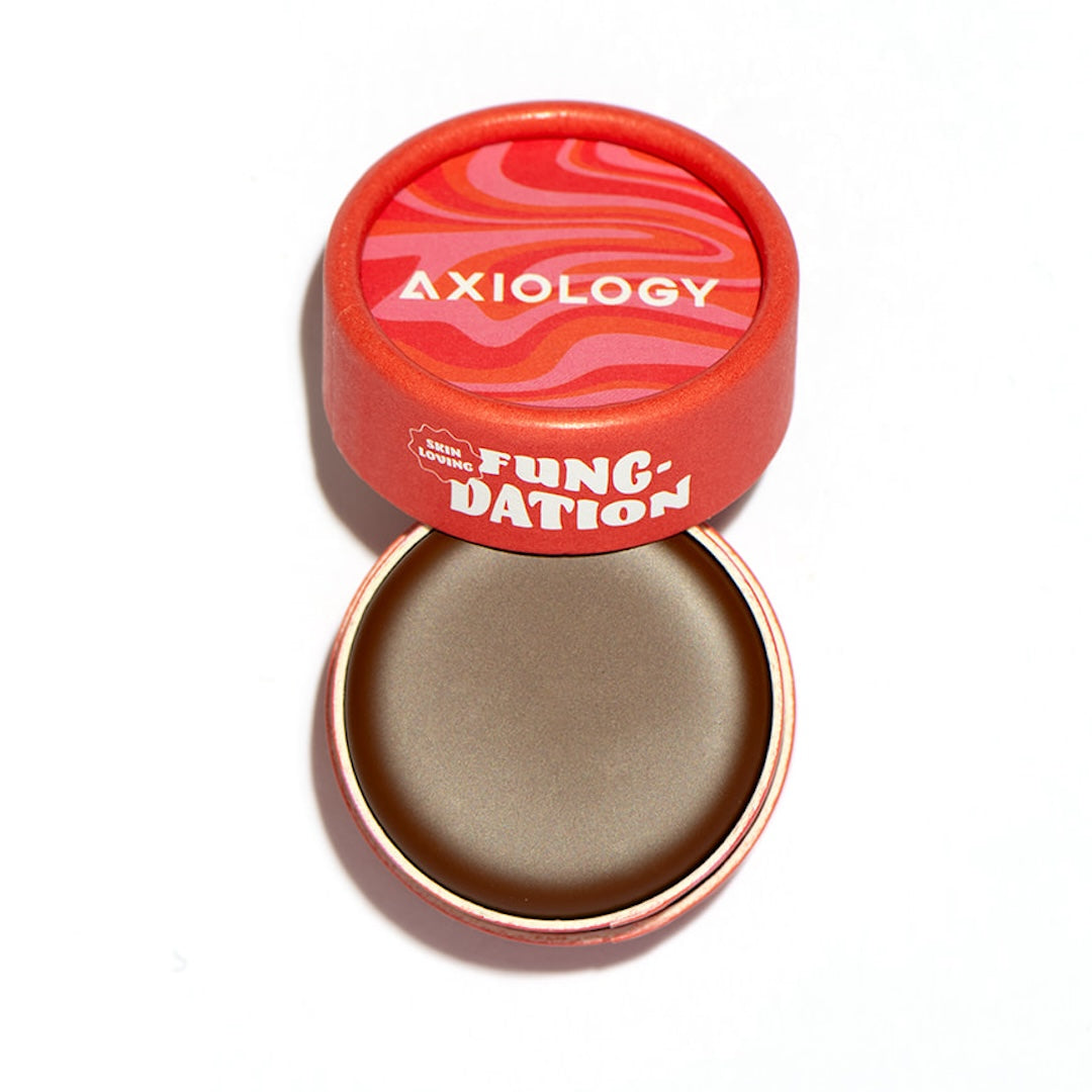 Brown foundation product with 'Axiology' branding on a white background