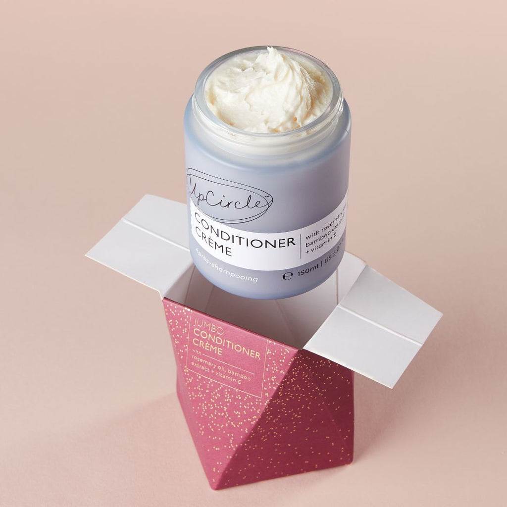 Jar of conditioner crème with pink packaging on a beige background