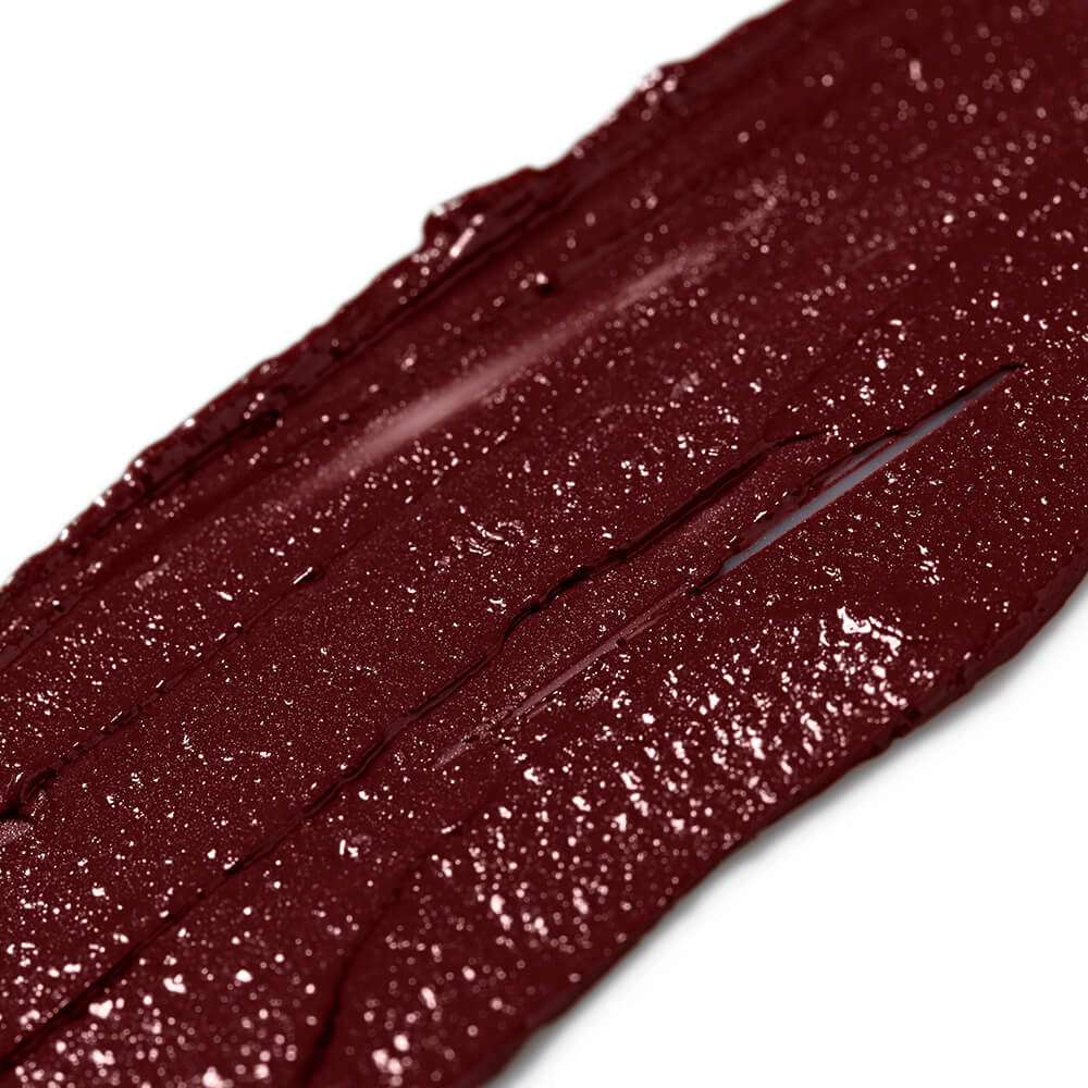 Close-up of a dark red lip gloss with glitter on a white background