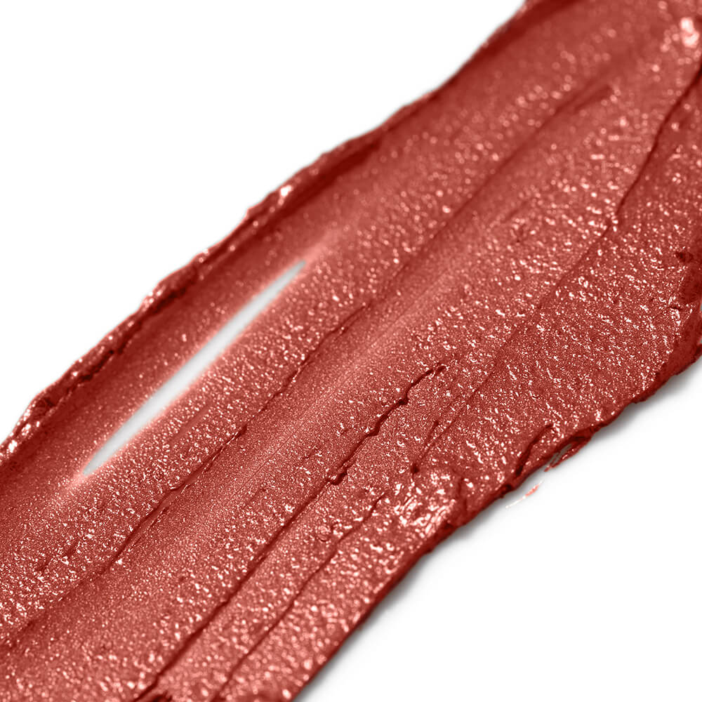 Close-up of a swatch of coral red lipstick on a white background