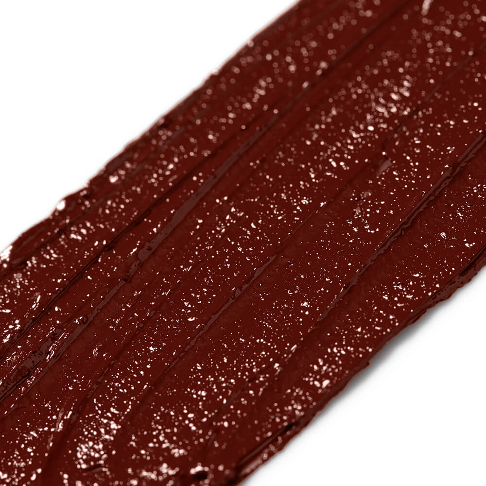 Close-up of brick red lipstick with a glossy texture on a white background