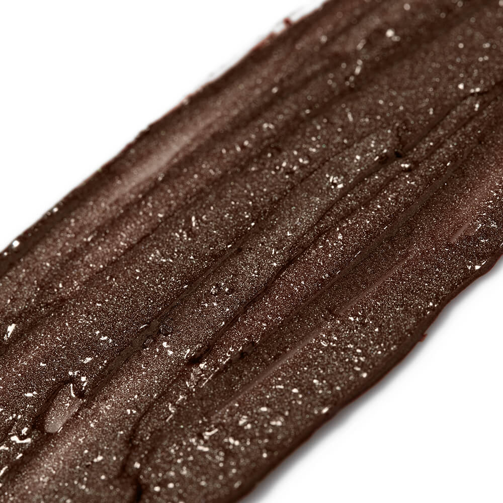 Close-up of a brown makeup swatch with glitter on a white background