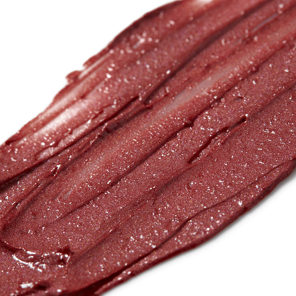 Close-up of a swatch of dark red lipstick with a glossy finish on a white background