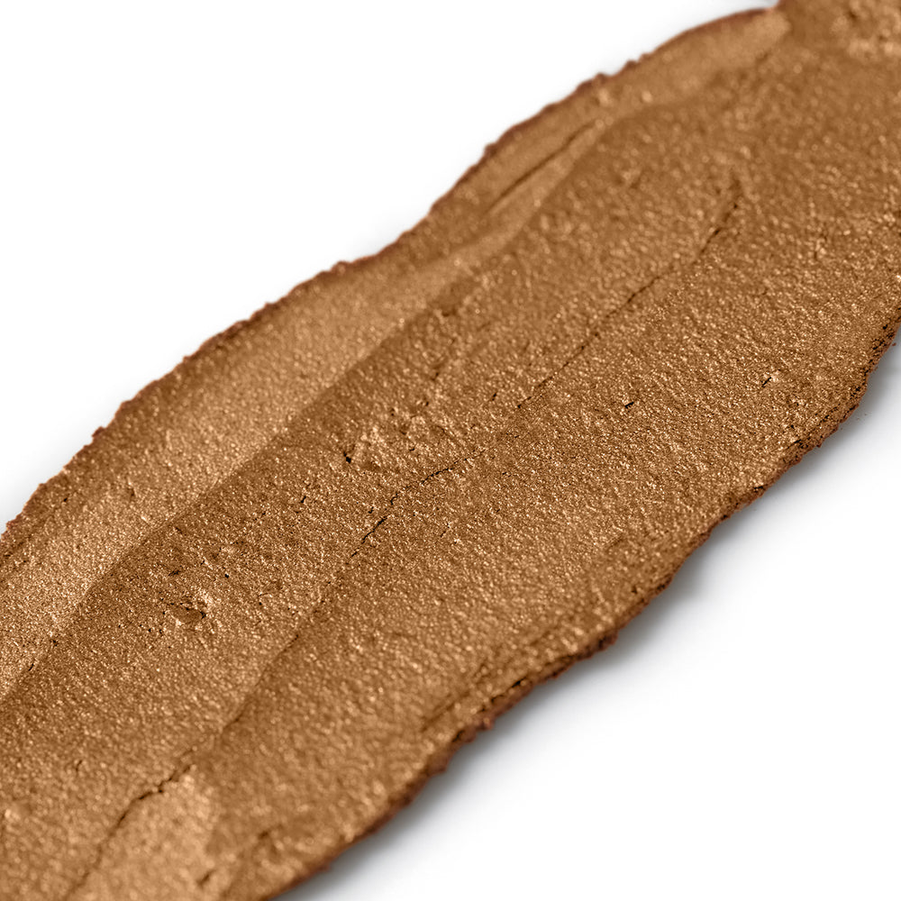 Close-up of a swatch of brown makeup cream on a white background