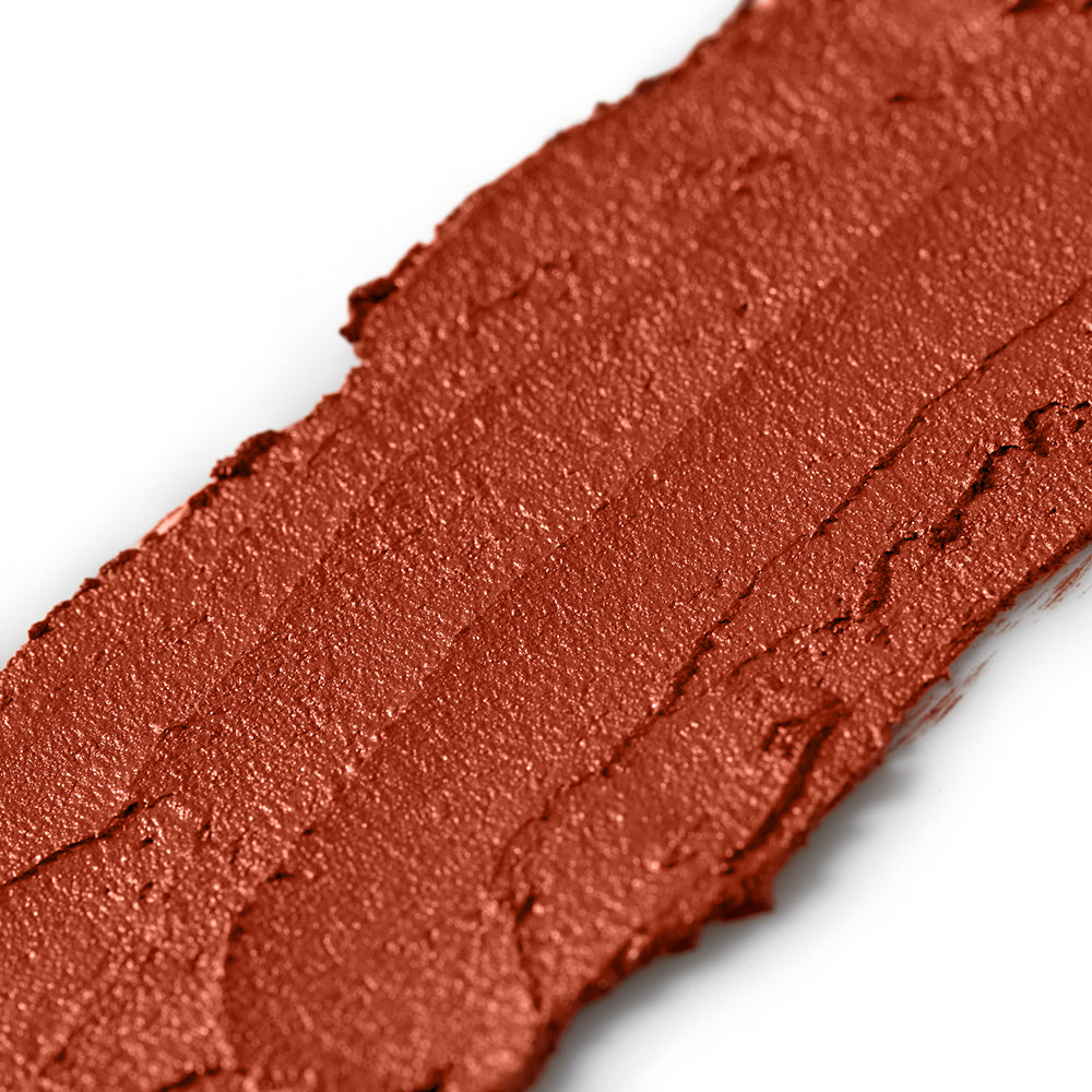 Close-up of a swatch of red-brown makeup on a white background
