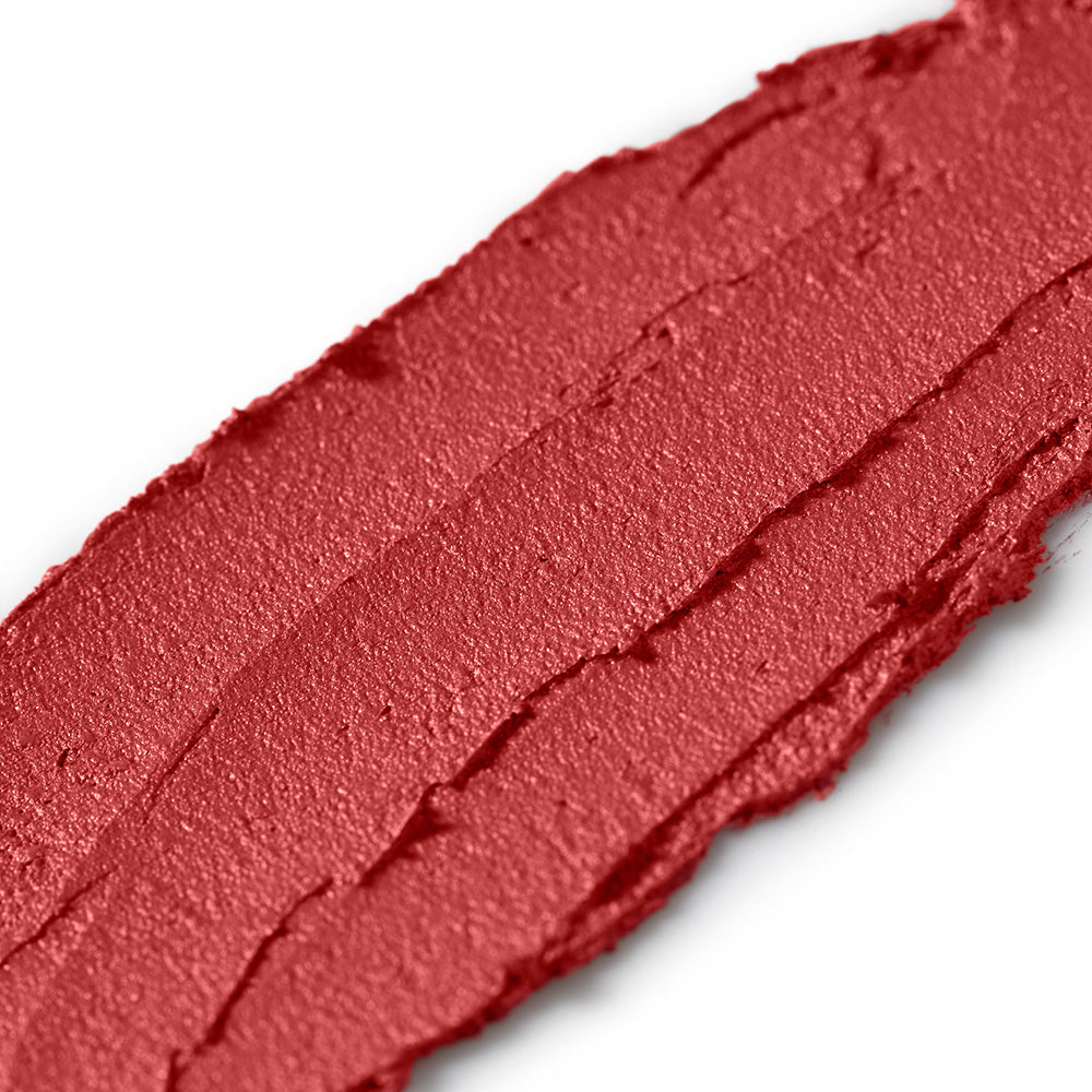 Close-up of a swatch of red lipstick on a white background