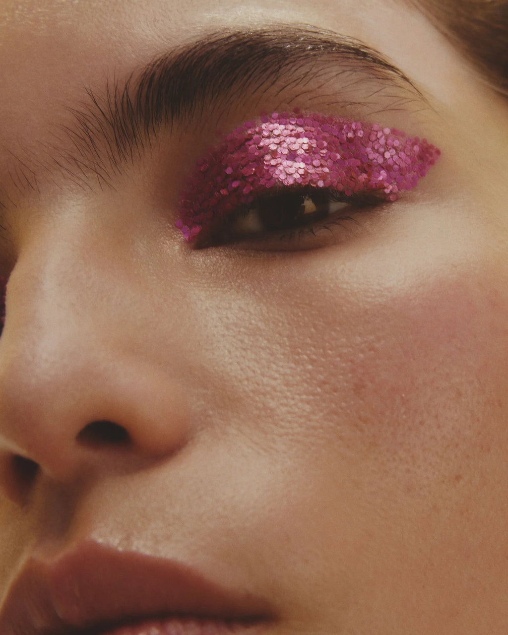 Close-up of a person's eye with pink glittery eye makeup
