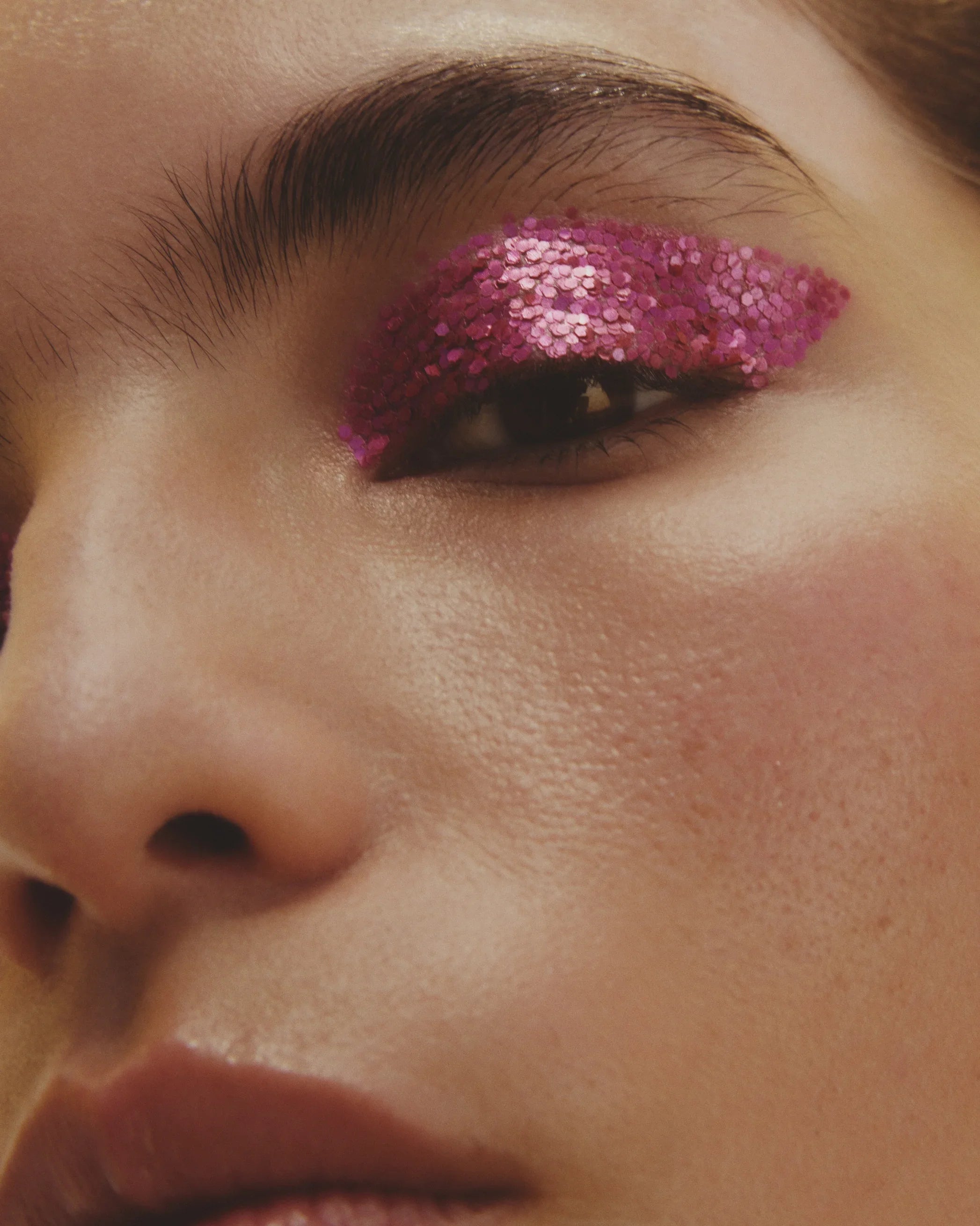 Close-up of a person's eye with pink glittery eye makeup