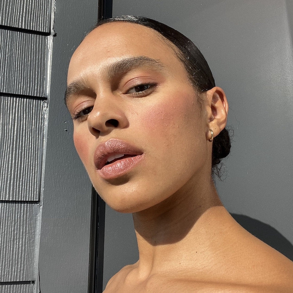 Close-up of a person with a neutral expression against a gray background