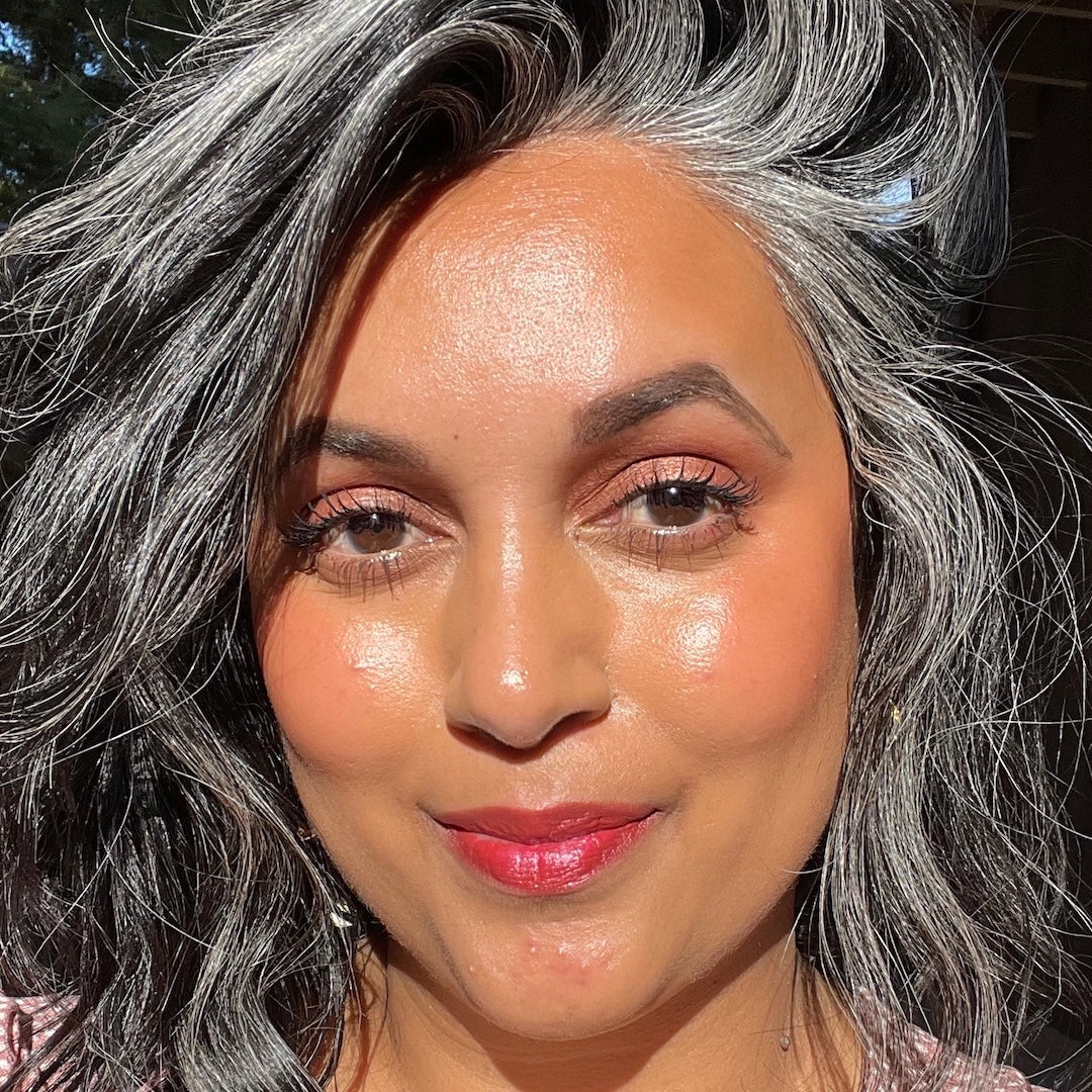 Woman with gray hair and pink lipstick outdoors