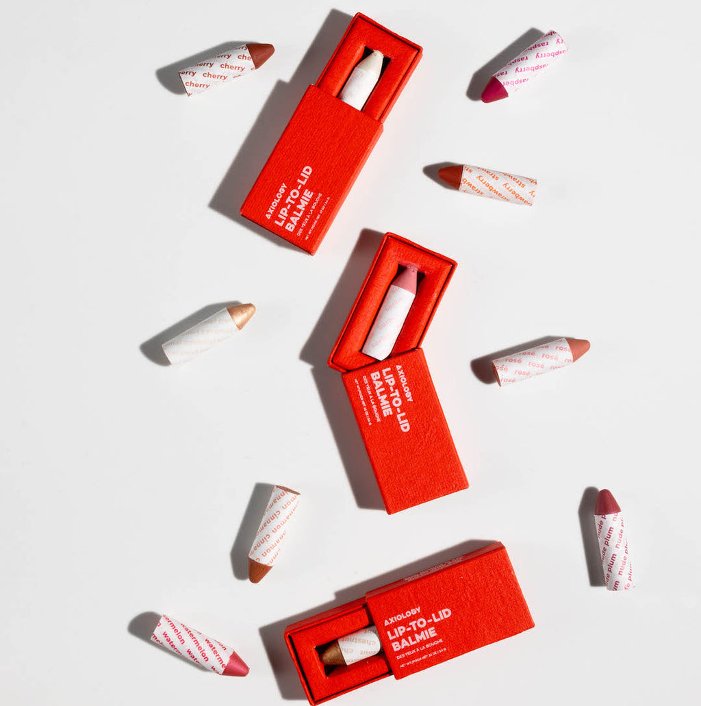 Red lip crayon packaging with visible lip crayon sticks on a white background