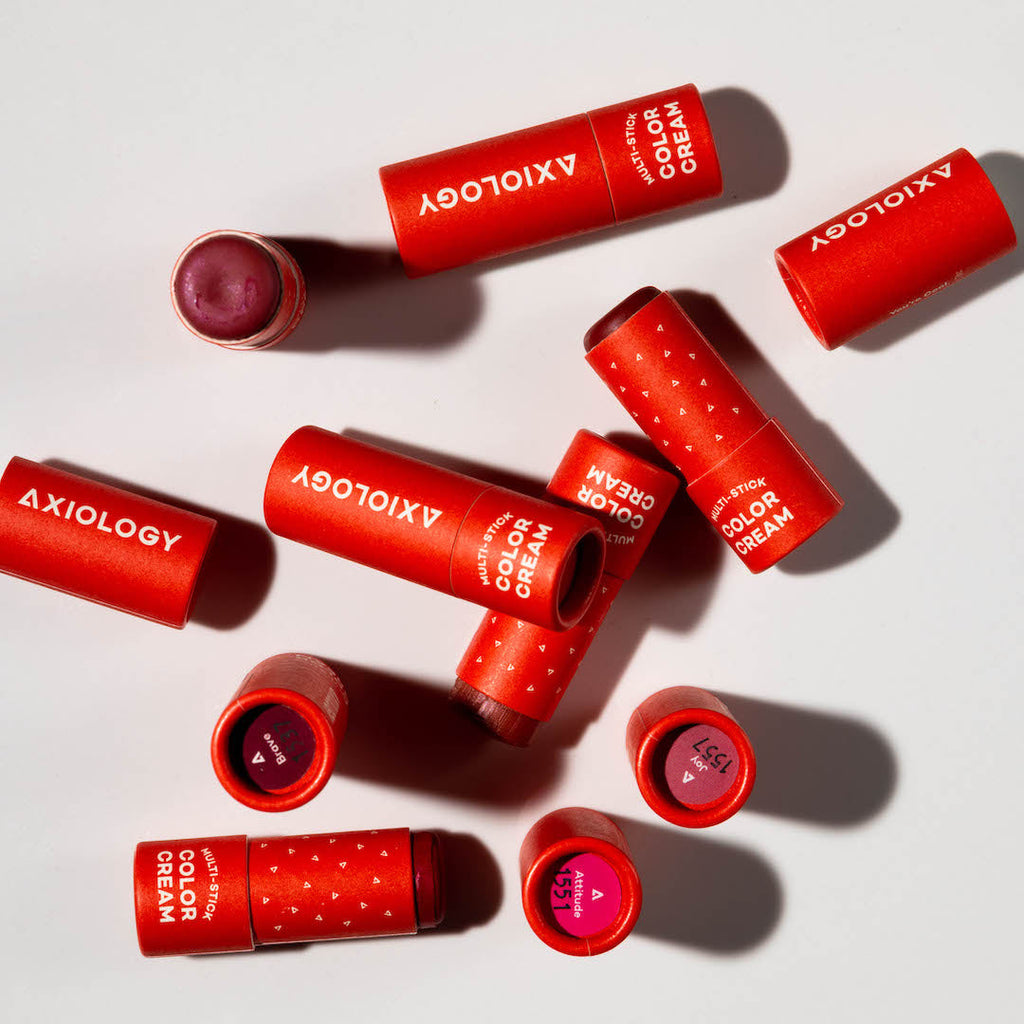Red Axiology color cream sticks on a light background
