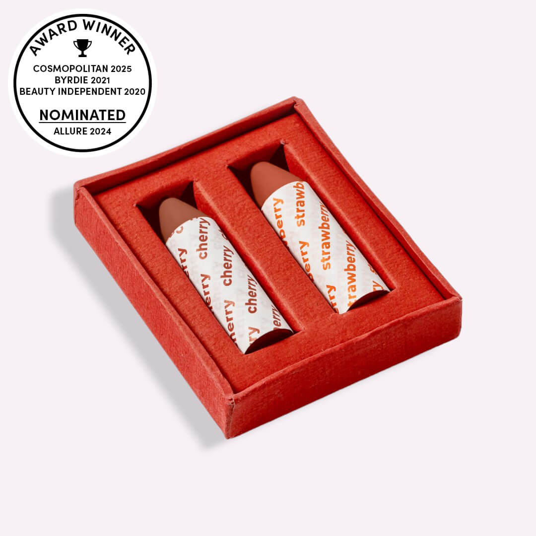 Two lip balms in a red box with awards on a white background