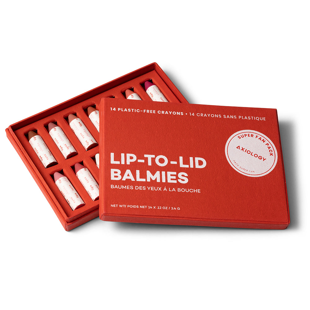 Red box of Lip-To-Lid Balmies with makeup crayons on a white background