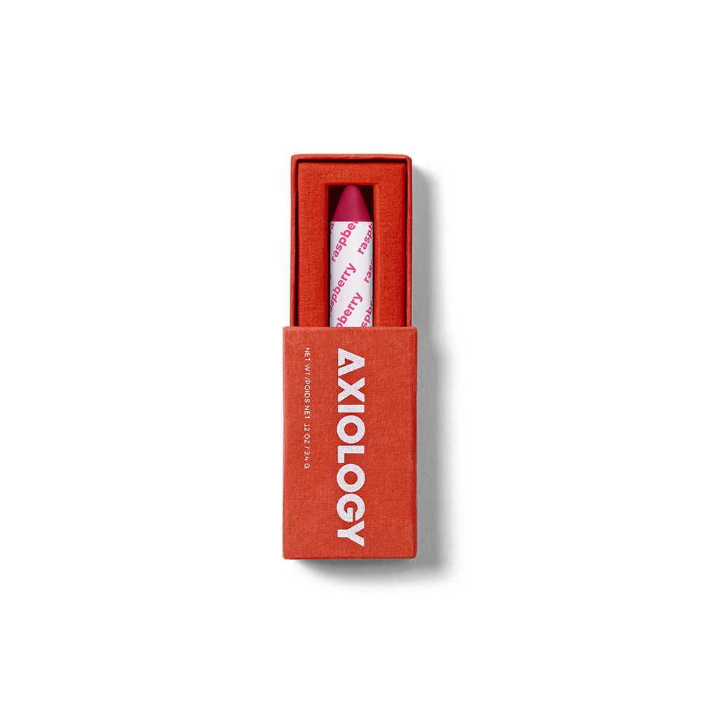 Pink lipstick in a red box with 'Axiology' branding on a white background