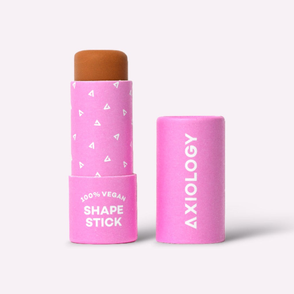 Pink Axiology shape stick with brown top on a white background