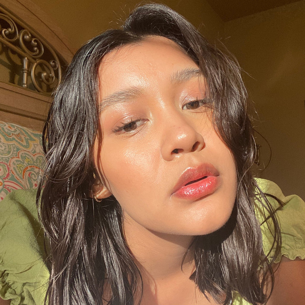 Woman with long dark hair wearing makeup in an indoor setting