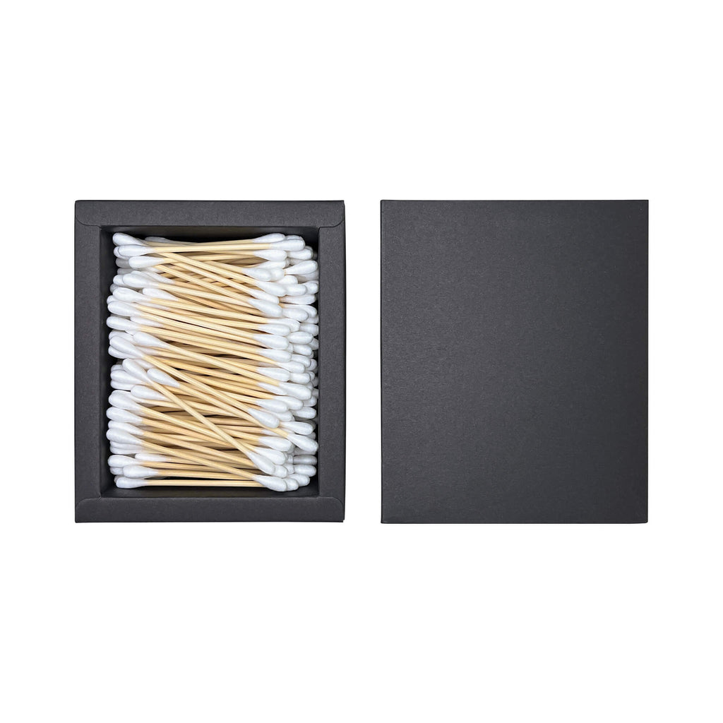 Open box of cotton swabs on a white background