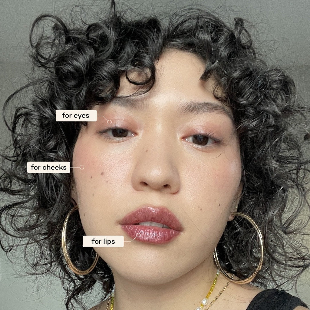 Close-up of a person wearing makeupwith text labels for makeup application on eyes, cheeks, and lips.