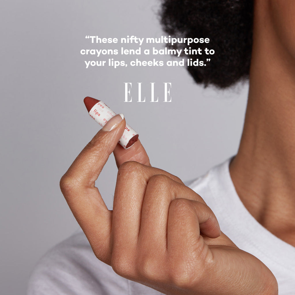 Hand holding a makeup crayon with ELLE branding and text about its uses.