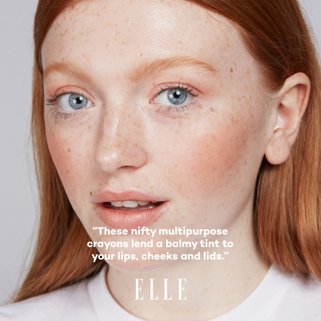 Close-up of a person with red hair and freckles, wearing makeup, with text overlay and 'ELLE' branding.