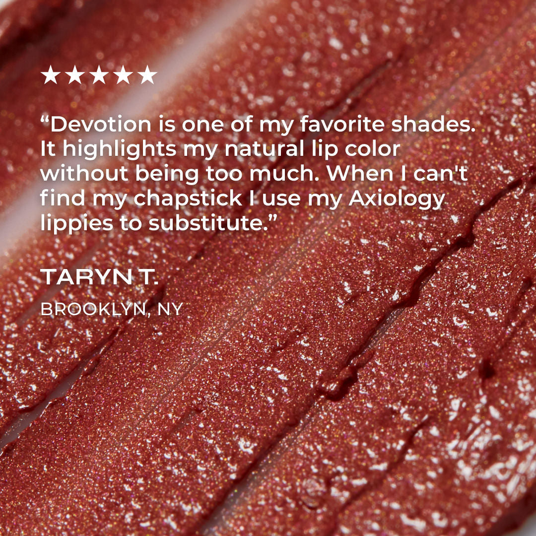 Close-up of a glossy lip product with a quote and name on it