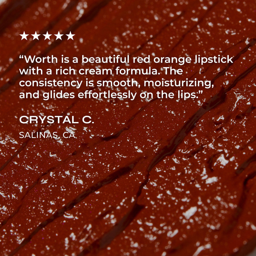 Close-up of a red-orange lipstick with a review text overlay on a dark background