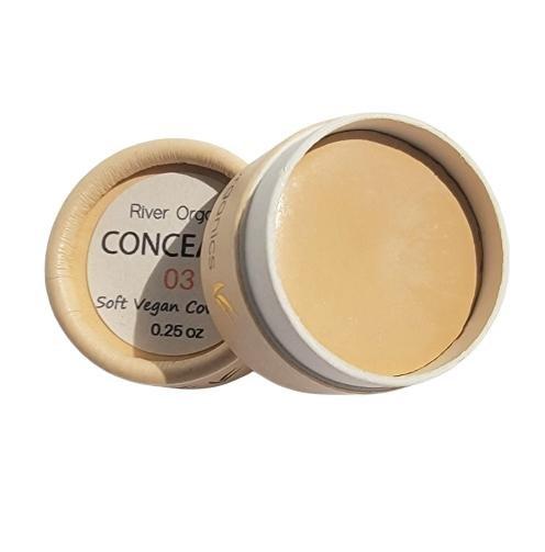 Open container of concealer with visible brand name on a white background