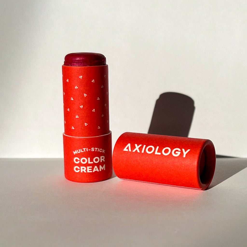 Red Axiology multi-stick color cream on a light background