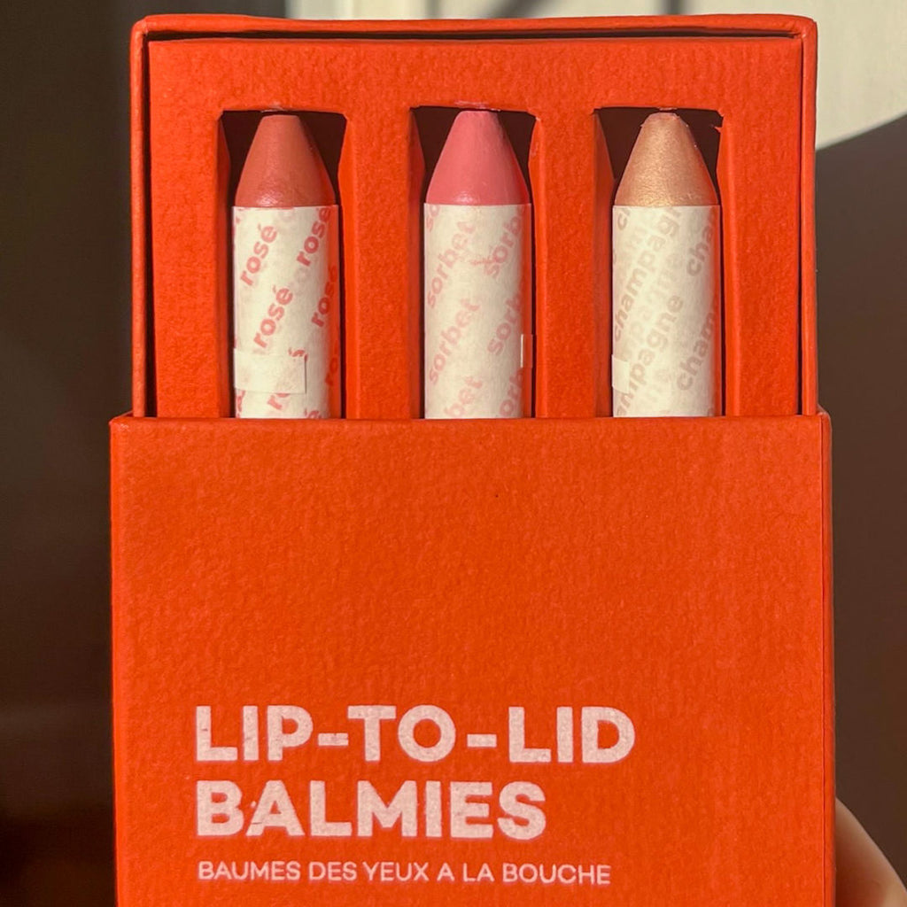 Set of lip-to-lid makeup crayons in a red box with visible branding.