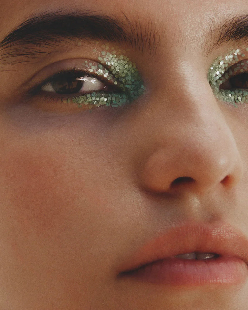 Close-up of a person's eye with green glitter makeup