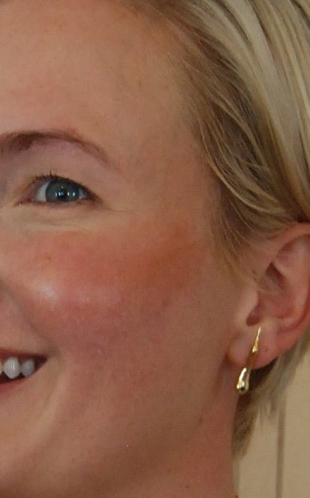 Close-up of a person wearing bronzer stick with a neutral background