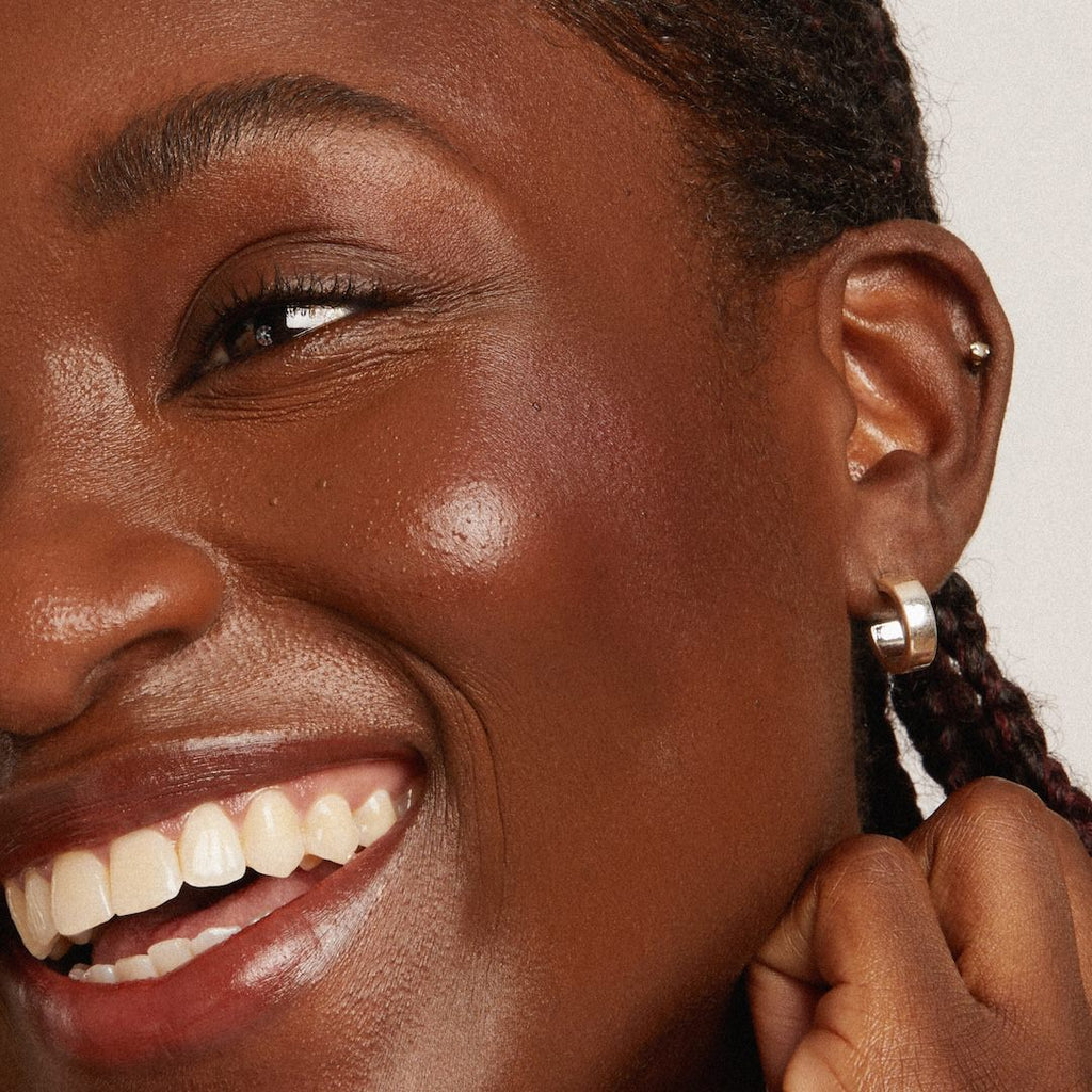 Close-up of a woman's face with a smile, wearing makeup