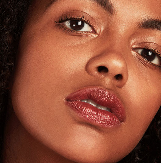 Close-up of a woman's face wearing makeup with a focus on her lips and eyes.