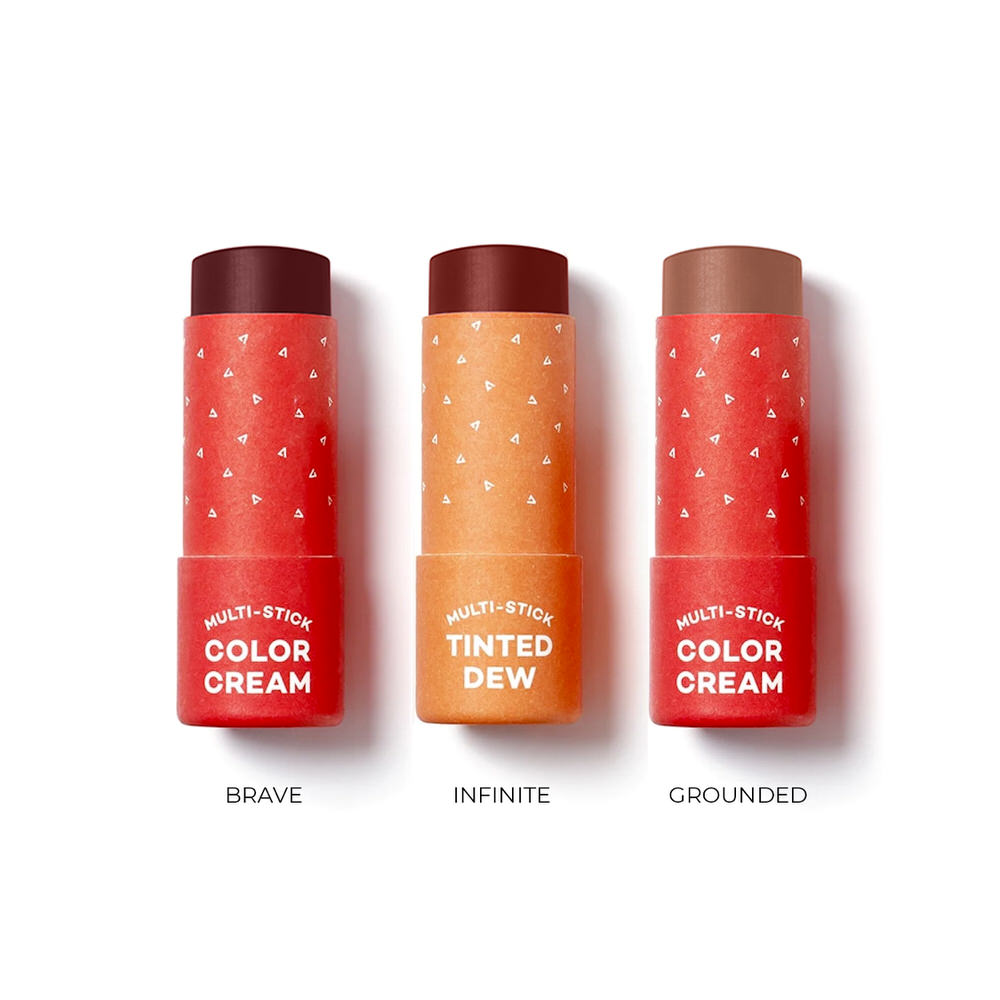 Three red and orange mkaeup sticks with labels on a white background