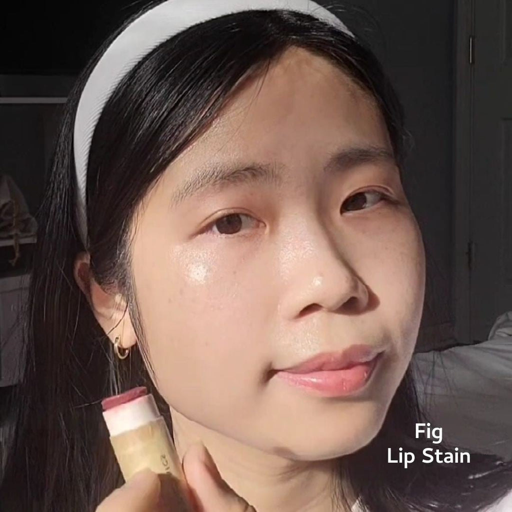 Person holding a lip stain product with a neutral background