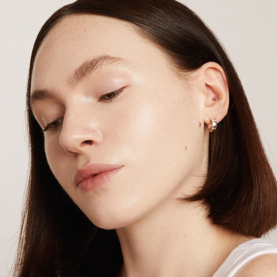 Close-up of a woman wearing foundation makeup with a neutral background