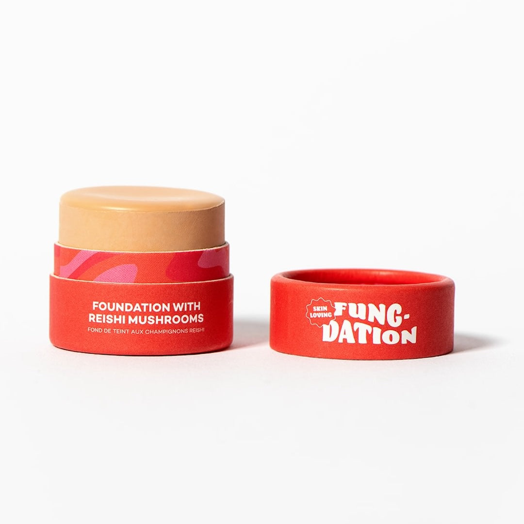 Red costmetic pot with beige foundation and red lid with 'Fung-Dation' text, on a white background.