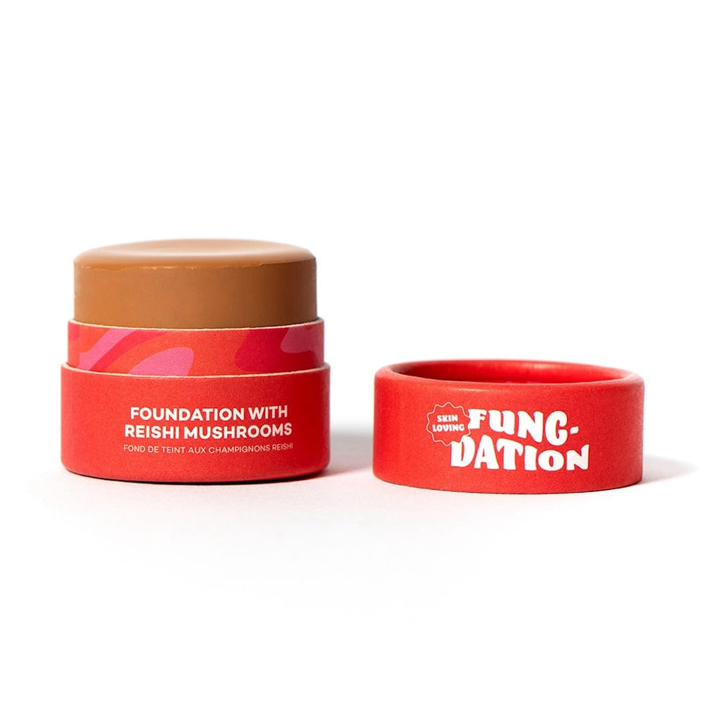 Red cosmetic pot with brown foundation and red lid labeled 'Fung-Dation' on a white background