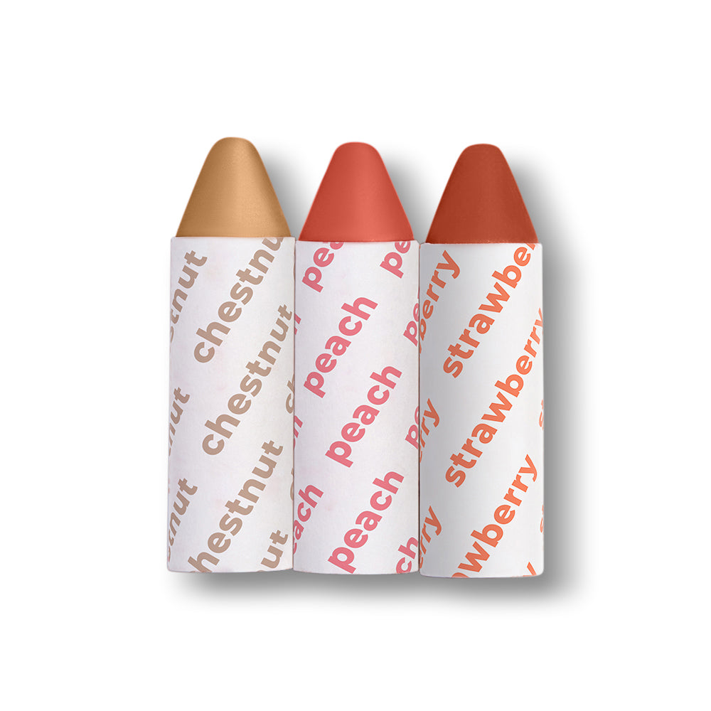 Three lip crayons labeled 'chestnut', 'peach', and 'strawberry' on a light gray background
