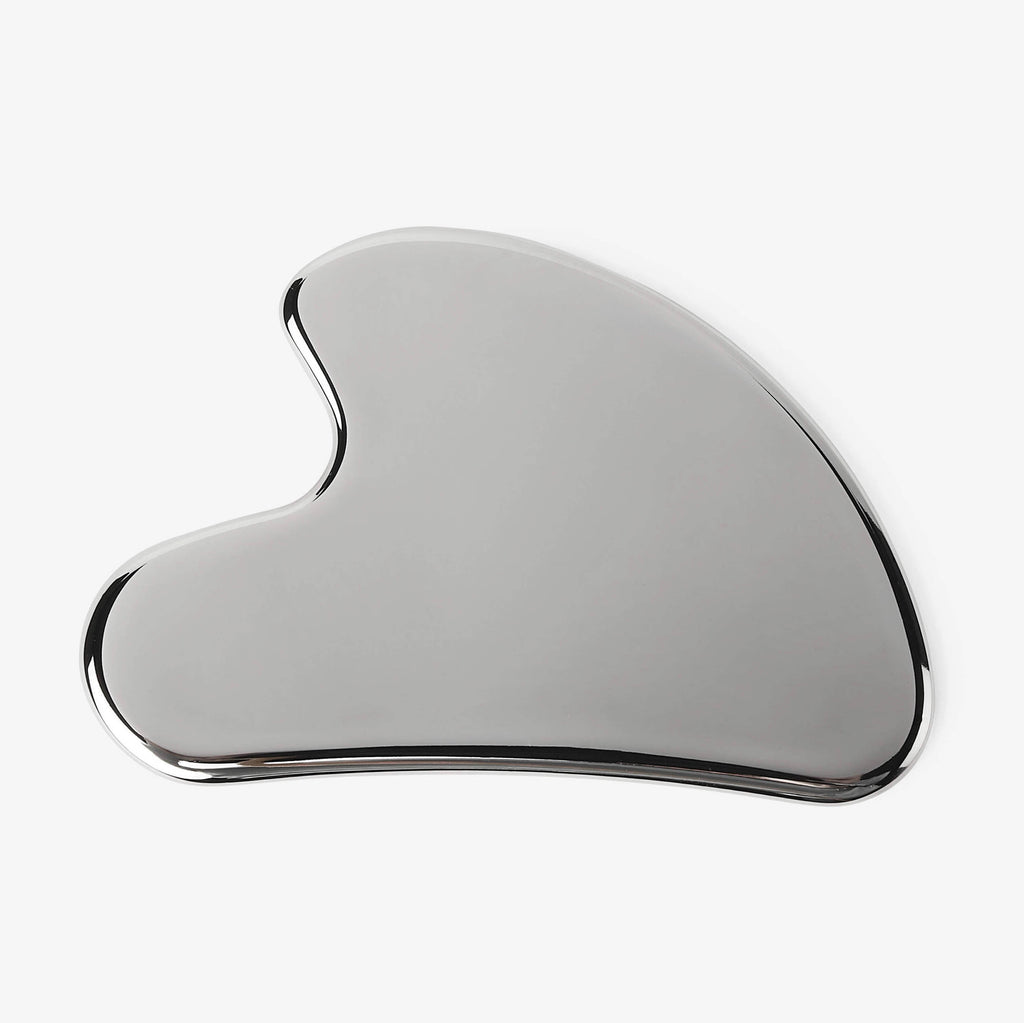 Silver Gua Sha tool on a white background