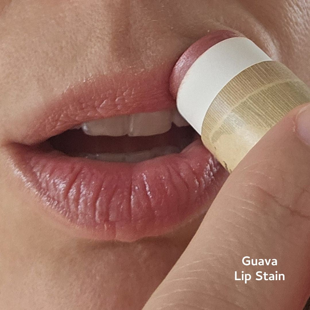 Lip stain being applied to a lip with 'Guava Lip Stain' text.