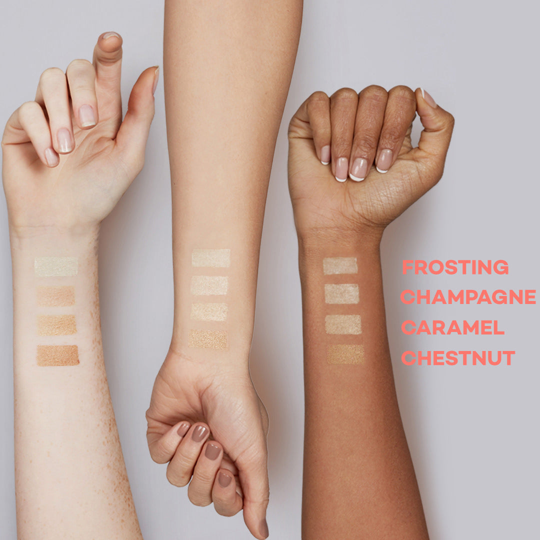 Three hands with makeup swatches labeled 'Frosting', 'Champagne', 'Caramel', and 'Chestnut' on a light background.