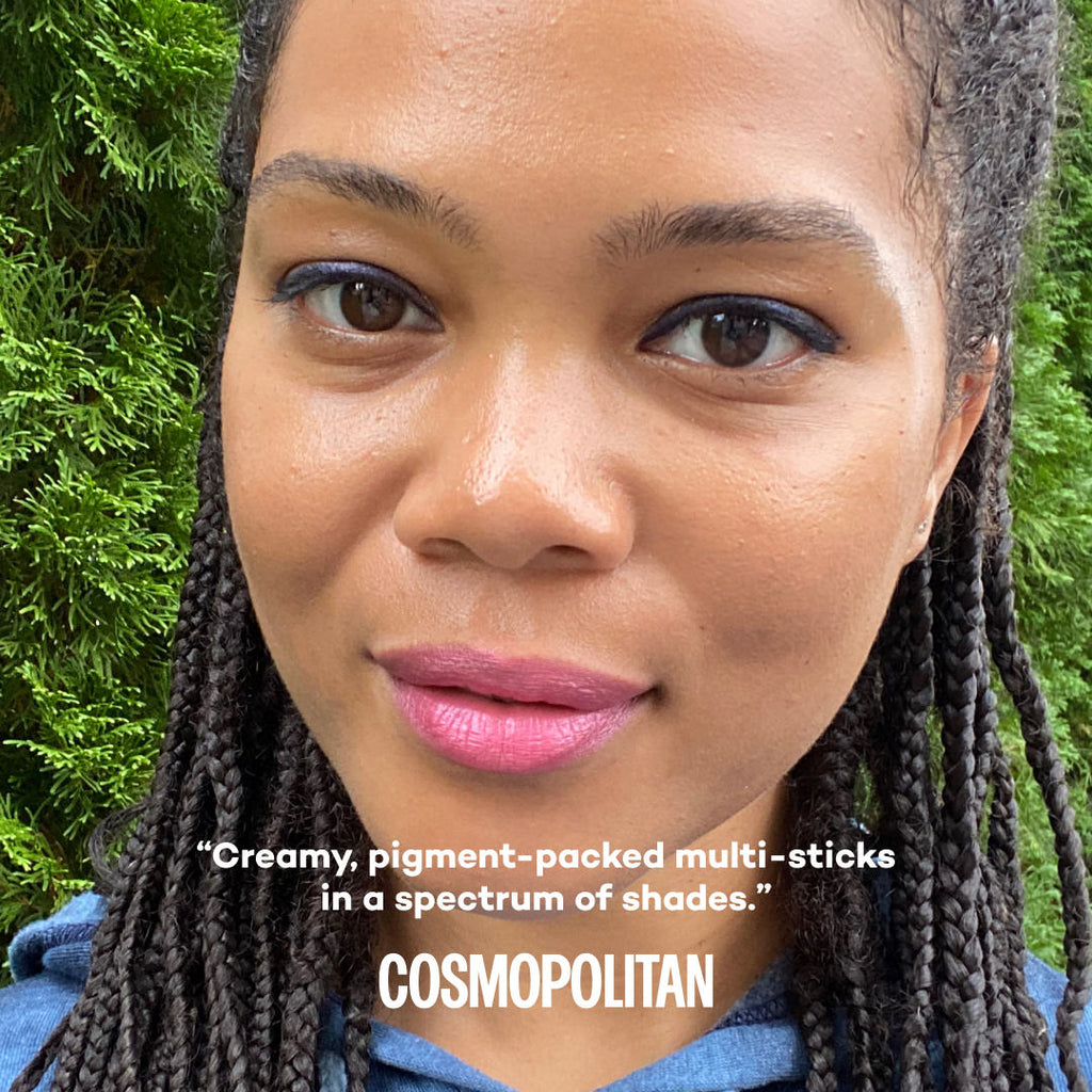 Woman with braided hair and pink lipstick against a green background, with text by Cosmopolitan about product.
