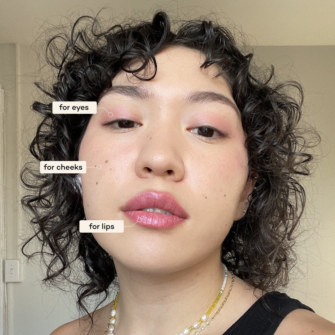 Person wearing makeup with text labels for applying makeup to eyes, cheeks, and lips.