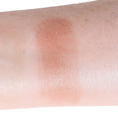 Close-up of a swatch of bronzer makeup on skin